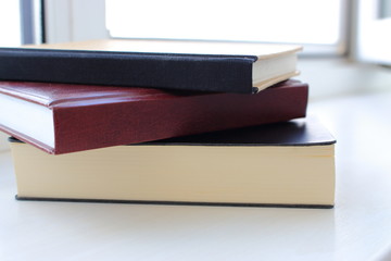 Pile of colored notebooks (books) on white background as education theme.