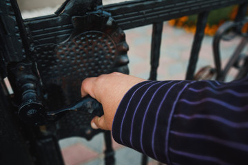 Fototapeta premium Fence. Hand opening metal fence gate.