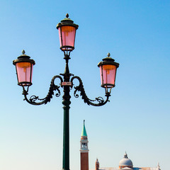 Fototapeta na wymiar August, 18, 2012, Venice, Italy: traditional Venetian pink lantern of three lamps on background of a blue sky