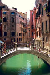 Fototapeta na wymiar August, 18, 2012, Venice, Italy: empty bridge through a small canal among old houses in venice