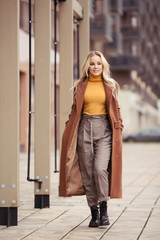 Blonde woman wearing in stylish coat in city