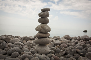 Fototapeta na wymiar balancing the stone tower against the sea in the morning