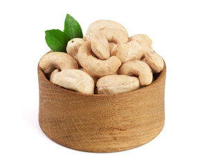 Cashew in a wooden bowl with leaf isolated on white background
