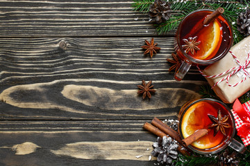 christmas hot mulled wine with cinnamon, anise and fir tree branches with gift boxes