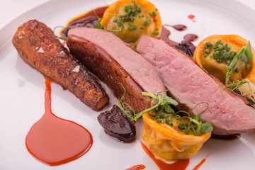 The duck glazed by carrots, is served with dates, pelmeni from a duck liver in the Red Wine sauce