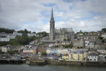 Fototapeta na wymiar Vue de Ringaskiddy à la sortie du port de Cork en Irlande. Maisons colorées et cathédrale de St Colmans