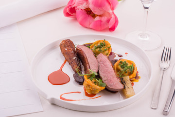 The duck farmer, glazed by carrots, is served with pelmeni from a duck liver with dates and duck hearts in the Red Wine sauce