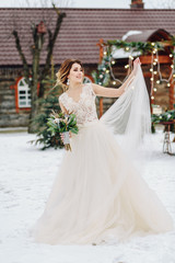 Plakat Gorgeous girl in white wedding dress walking in winter park.