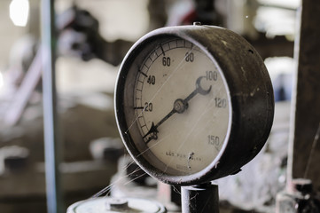 Old pressure gauge on a pump manufactured around 1940.