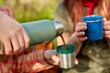 Two women enjoying hot coffee on a hike