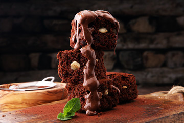 Cake chocolate brownies with dark chocolate dressing and mint on wooden table.
