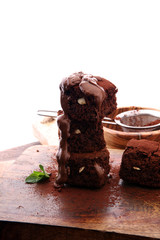 Cake chocolate brownies with dark chocolate dressing and mint on wooden table.