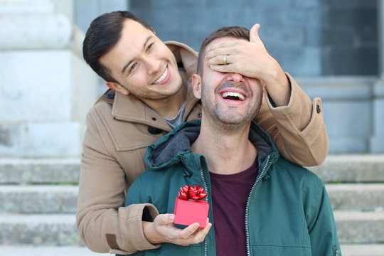 Man surprising his boyfriend with a present