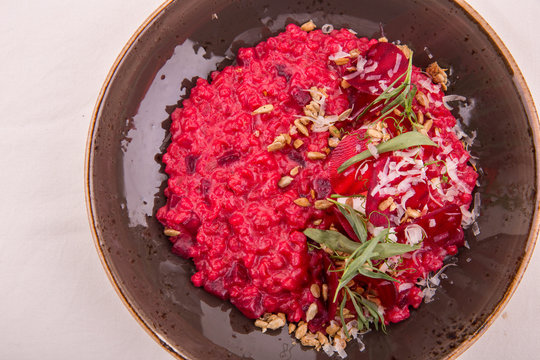 Beet орзотто with goat cheese and pine nuts, parmesan and rosemary is served with cheese