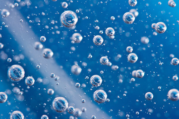 Large beautiful Oxygen bubbles underwater on a blue background macro.