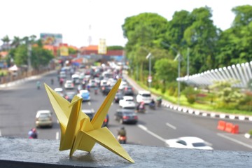 Origami geese stands on pedestrian bridge. into a single Object in the city landscape background.