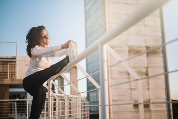 Fitness girl stretching leg on outdoor