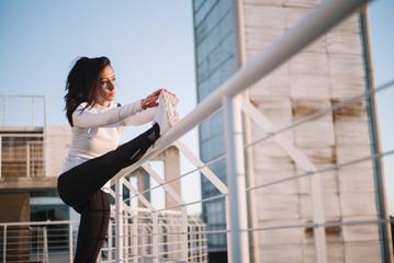 Fitness girl stretching leg on outdoor