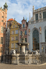 Fototapeta na wymiar View of the Neptune Fountain in front of old historic buildings at Long Market Street (Long Lane) at the Main Town (Old Town) in Gdansk, Poland, on a sunny day.