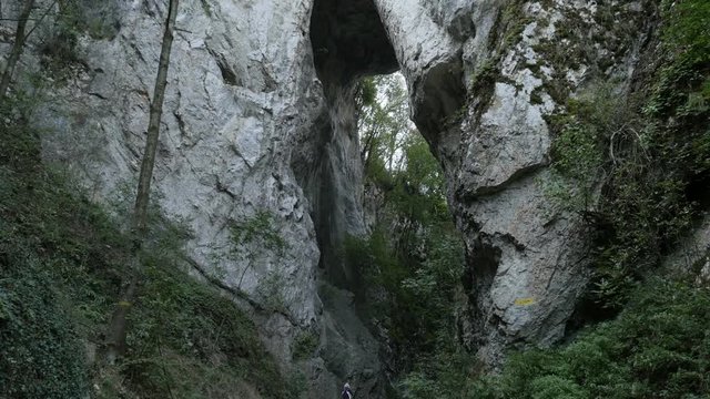 Arch and nature of Eastern Serbia footage - Hiker under natural stone bridge
