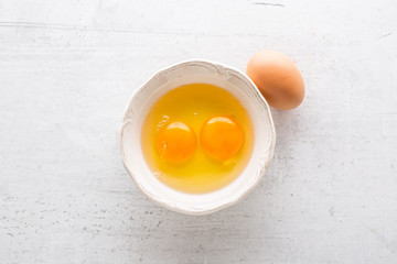 Top of view eggs in bowl on white concrete board