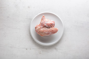 Top of view frozen turkey chicken on white plate with fork and knife