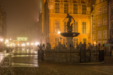 Fountain of the Neptune in Old Town of Gdansk in the fog at night.  Poland.