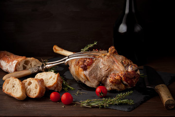 Freshly roasted lamb leg with herbs and bottle of red wine © netrun78