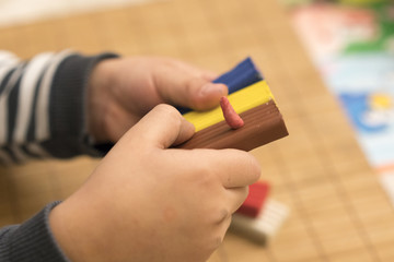 Children's hands hold the clay of different colors