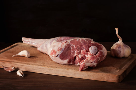 Fresh raw lamb leg ready for roasting with garlic