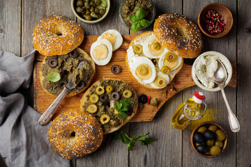 Sandwich  from bread or bagels with tapenade, olives and boiled chicken eggs on an old wooden background. Selective focus. Top view. Copy space.