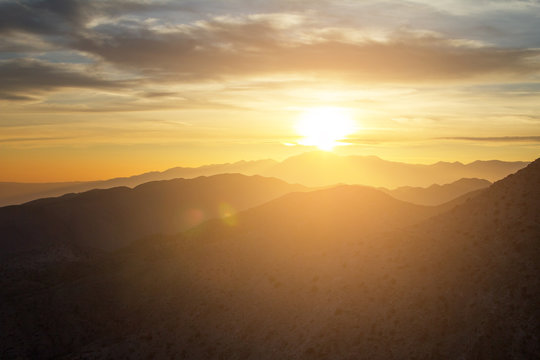 Glowing sunset view over the desert mountain landscape of Joshua Tree National Park in California