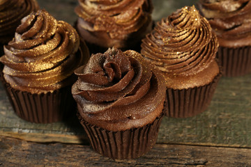 Tasty chocolate cupcakes on wooden table