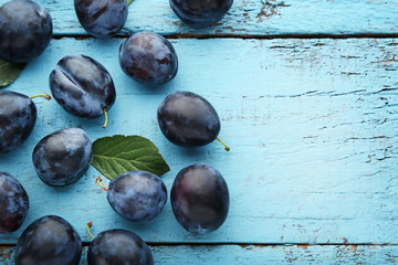 Ripe and sweet plums on blue wooden table