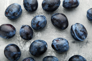 Ripe and sweet plums on grey wooden table