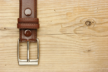 belt with a buckle on a wooden board