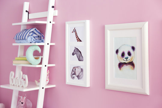 Shelves with toys and pictures of animals on wall in baby room
