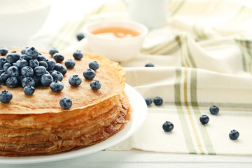 Pancakes with blueberries on white wooden table