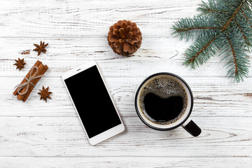 christmas decoration. smartphone, wooden table christmas tree branch, christmas cup coffee gift