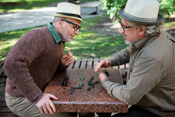 Joyful mature friends relaxing with intellectual game outdoor
