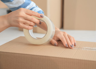 Young woman packing box, indoors