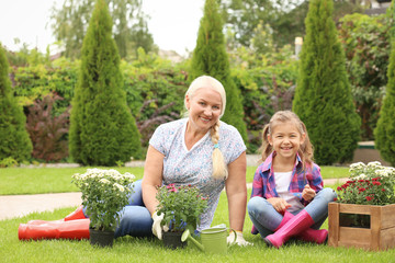 Elderly woman with granddaughter in garden