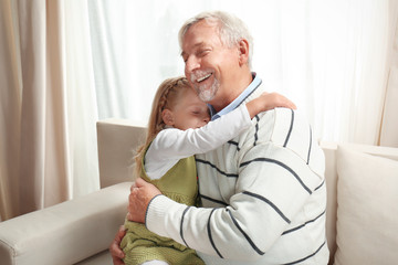 Elderly man with granddaughter at home