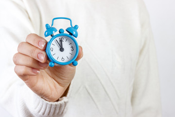 girl showing an alarm clock on white background
