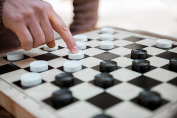 Naklejka premium Arm of man pushing chequer on board