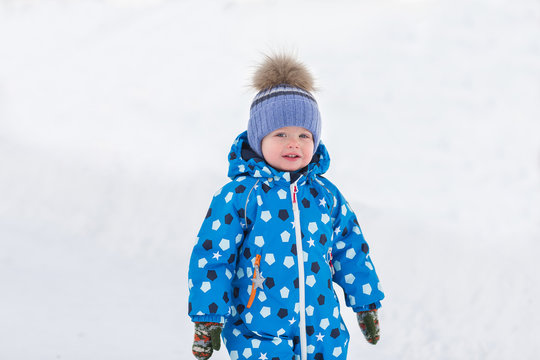 Little cute toddler boy walking outdoors on beautiful sunny winter day