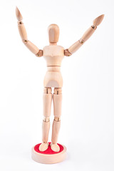 Wooden dummy standing with raised hands. Wooden mannequin raised hands over white background.