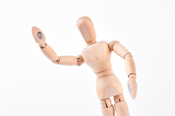 Wooden dummy showing greeting sign. Wooden figurine raised its hand over white background. Body...