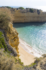 Einsamer Strand umringt von Felsen an der Algarve