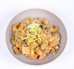 Risotto with mushrooms and chicken decorated with leek on a white background